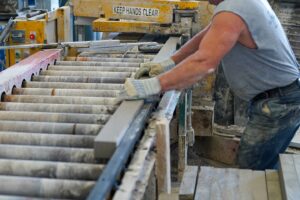 A worker guiding cut limestone through the B.G. Hoadley mill