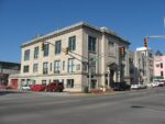 The John Waldron Arts Center from the southeast corner of 4th and Walnut: a three-story limestone building with a pedimented entrance on Walnut Street
