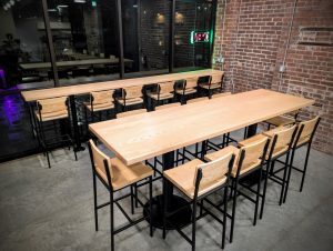 Modern wood table seating inside Soma Coffeehouse with exposed brick walls in Bloomington, Indiana