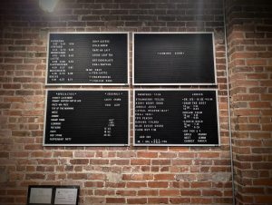 Menu boards displaying espresso, smoothies, and juices at Soma Coffeehouse in Bloomington