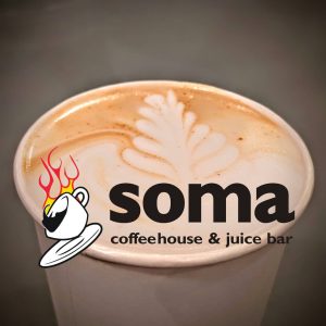 Close-up of latte with leaf latte art featuring Soma Coffeehouse & Juice Bar logo overlay in Bloomington, Indiana