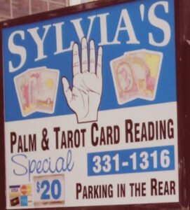 Sylvia's Palm and Tarot Card Reading sign offering a $20 special, with contact number 331-1316 and parking in the rear