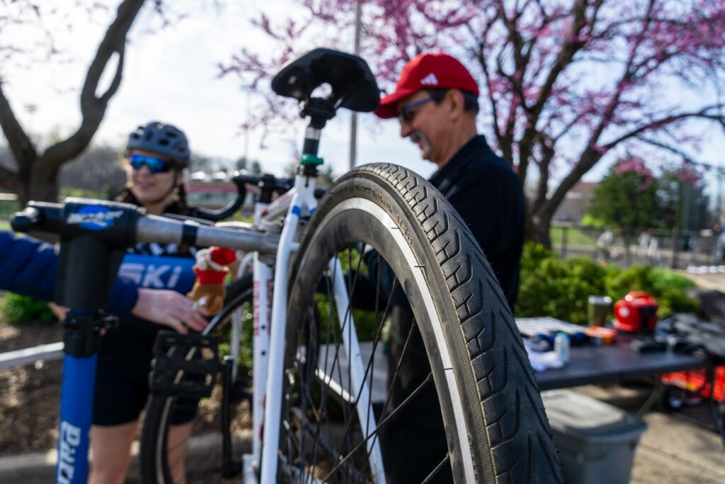 Bike mechanic Greg Souder assisting a student rider with bicycle maintenance at Little 500 practice.