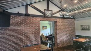 A brick-walled seating room at The SIP Craft Beer Pub