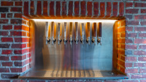 Ten tap handles in a brick alcove at The SIP Craft Beer Pub